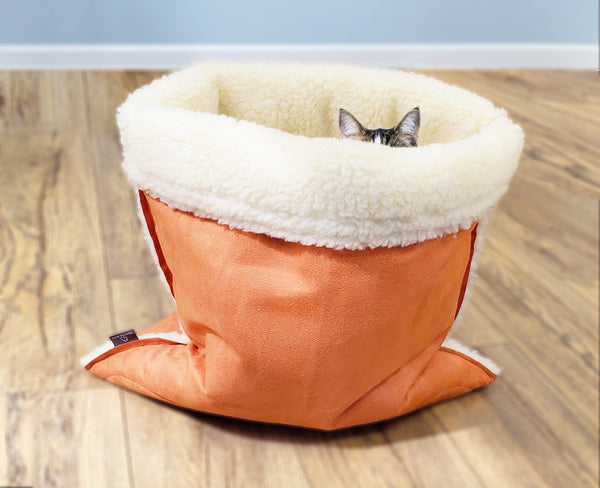 cat peeking out of a snuggle cave