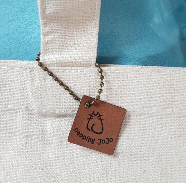 faux leather logo tag and chain close-up