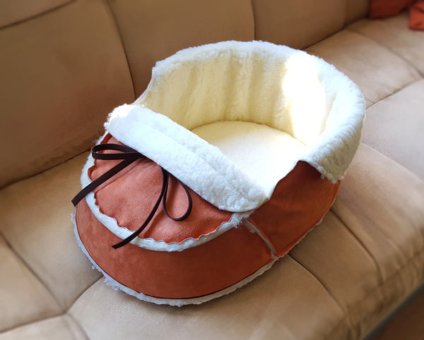 orange moccasin pet bed on a sofa