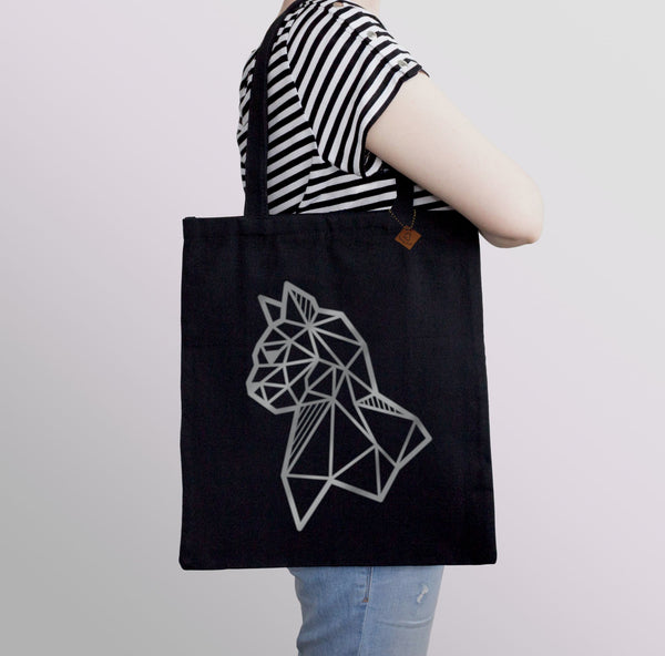 carrying a black tote bag with silver cat print